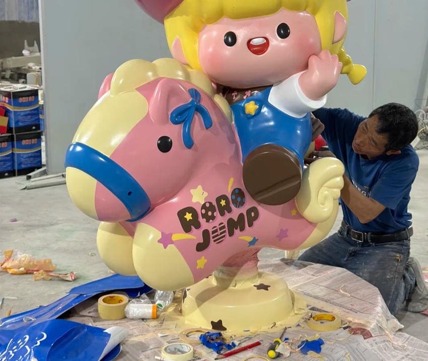 Custom fiberglass character sculpture being hand finished for a commercial attraction project